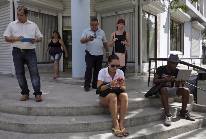 Cubans use the internet via public Wi-Fi in Havana