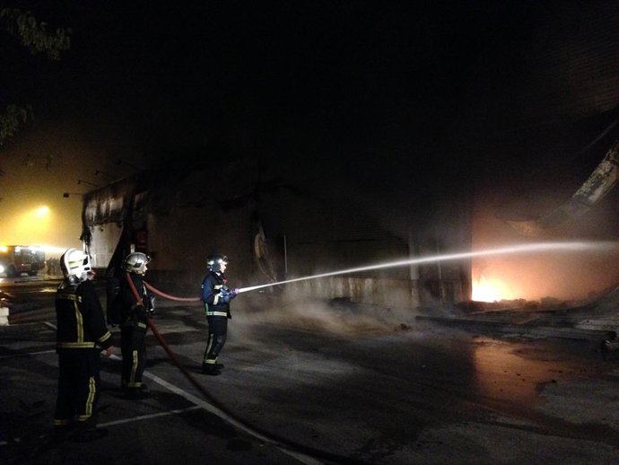 Bomberos en las labores de extinción del incendio en la gran superficie