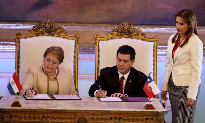 Paraguay's President Horacio Cartes and Chile's President Michelle Bachelet sign