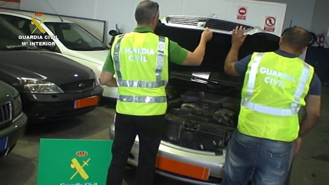 Agentes de la Guardia Civil inspeccionan uno de los vehículos