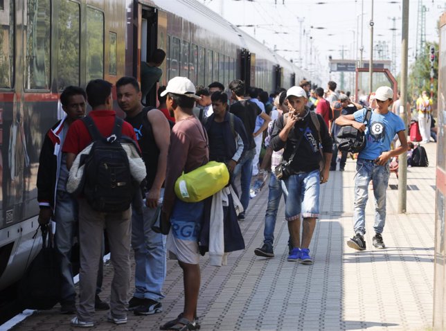 Refugiados subiéndose en un tren en la frontera entre Hungría y Austria