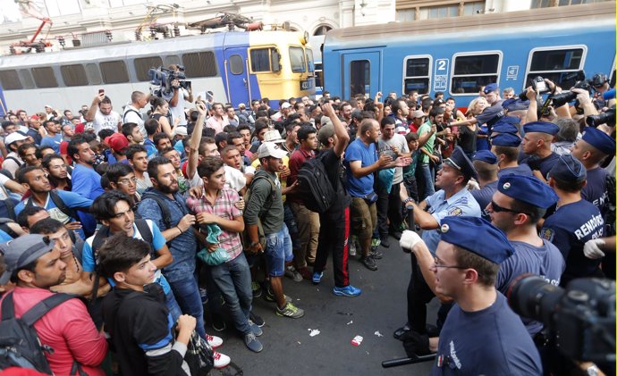 Inmigrantes frente a policías en una estación de Budapest