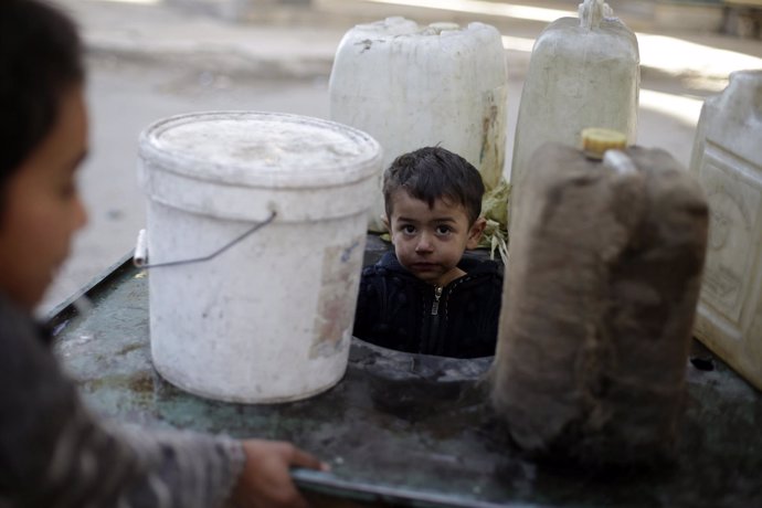 Niño sirio llenando cubos de agua en Douma, al este de al-Ghouta