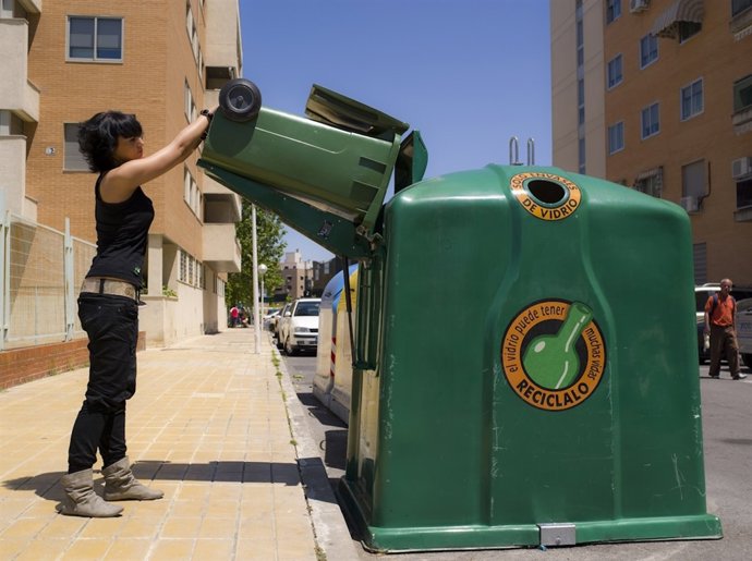 Una ciudadana recicla vidrio en un contenedor