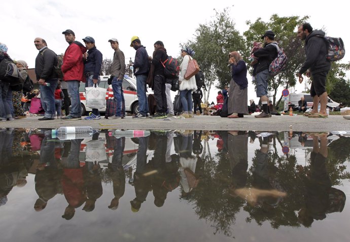 Refugiados hacen cola para acceder una estación de tren en Nickelsdorf , Austria