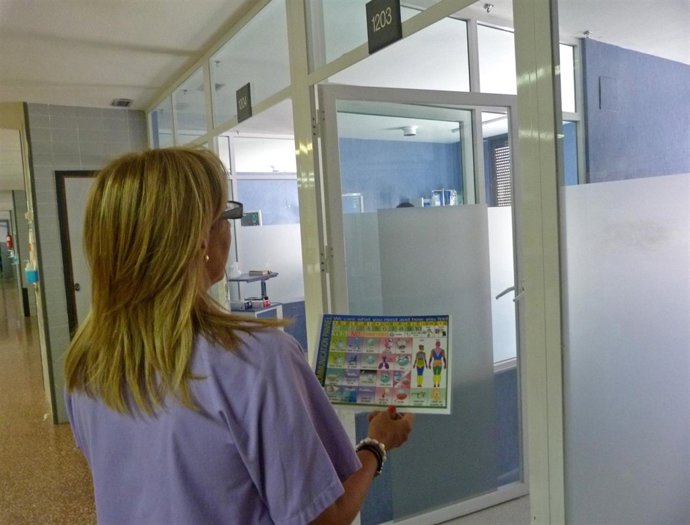 Una profesional de la UCI sostiene uno de los paneles de comunicación no verbal