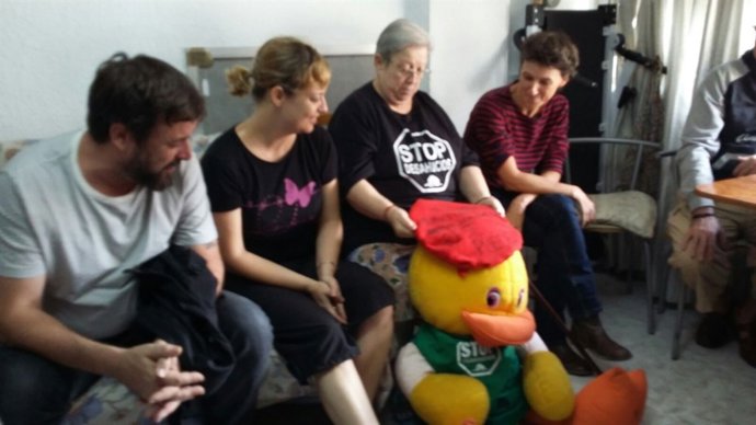 Rosa en su casa sosteniendo un peluche con la camiseta de la PAH