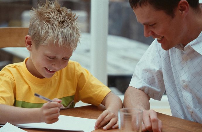 Padre con su hijo haciendo los deberes