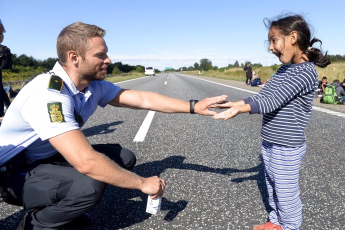 Policía danés juega con una niña refugiada