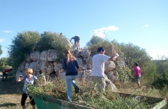 Voluntarios acondicionan un talaiot