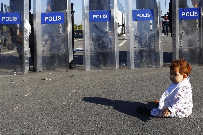 Un bebé frente a una barrera de policías antidisturbios turcos