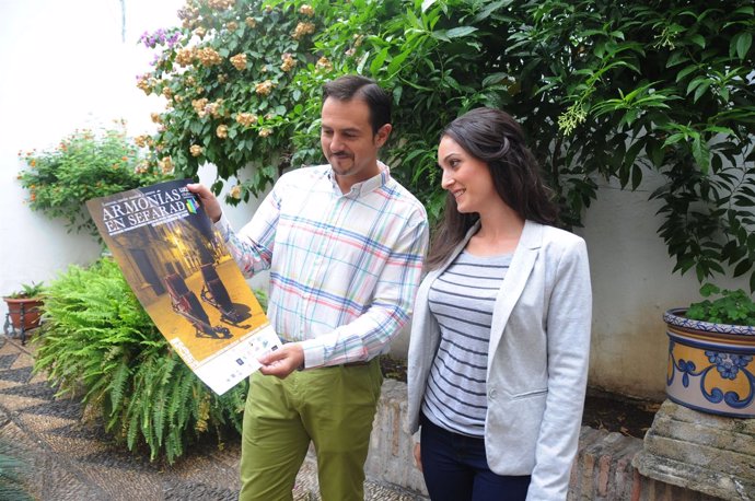 Gómez observa el cartel de la actividad que le muestra Lara