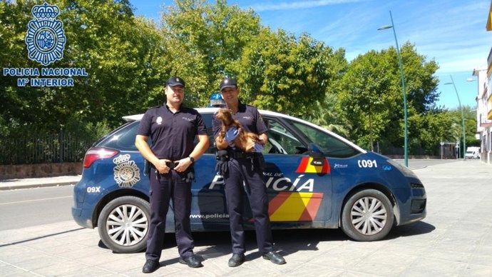 Agentes de la Policía Nacional con el cachorro de perro.