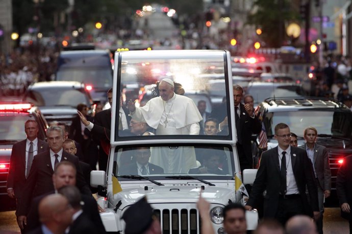 Pope Francis waves to the crowd as he rides down Fifth Avenue in New York