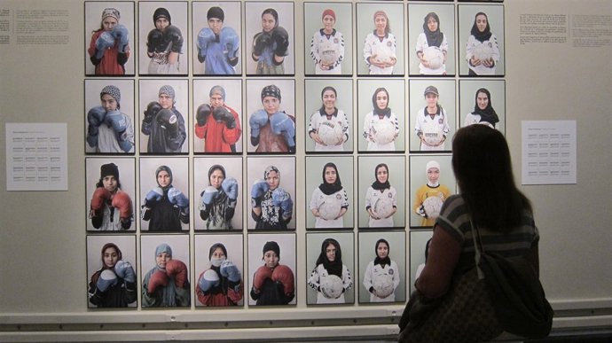 Una visitante contempla algunas de las fotografías que componen la muestra