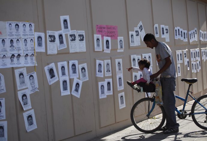 Niña señala fotos de los desaparecidos en Ayotzinapa