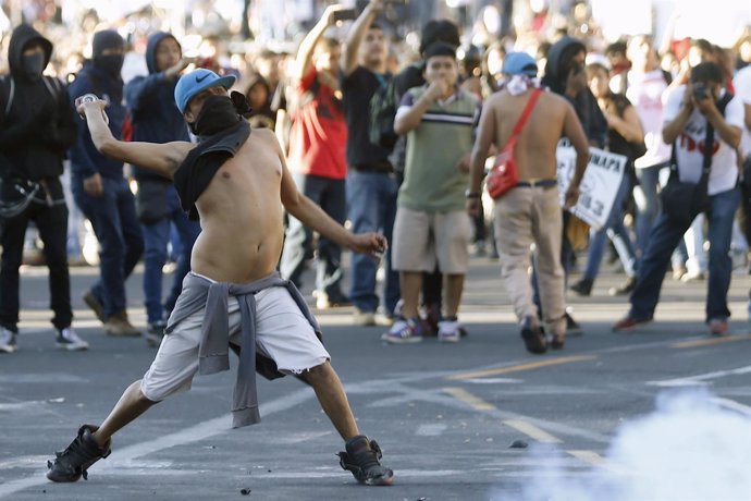 Un manifestante lanza un bote durante el aniversario de la Masacre de Tlatelolco