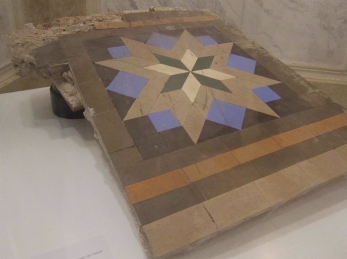 Una pieza del mosaico Nolla procedente del Palauet junto a la fábrica 