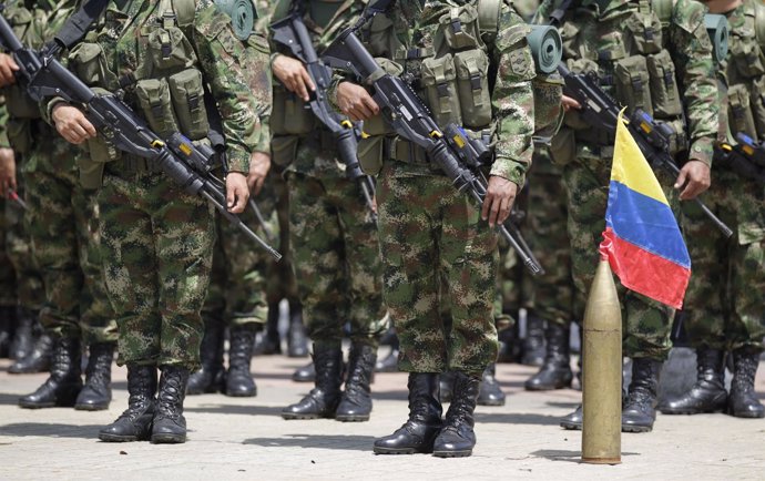 Colombian soldiers stand at attention next to their national flag during an inau