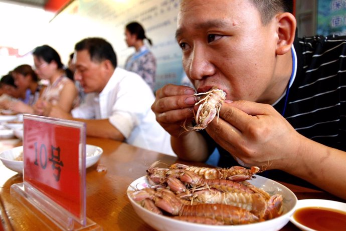 Participantes en un concurso de comer marisco en China