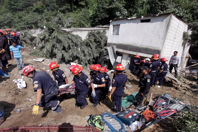 Rescue team members carry the body of a landslide victim in Santa Catarina Pinul