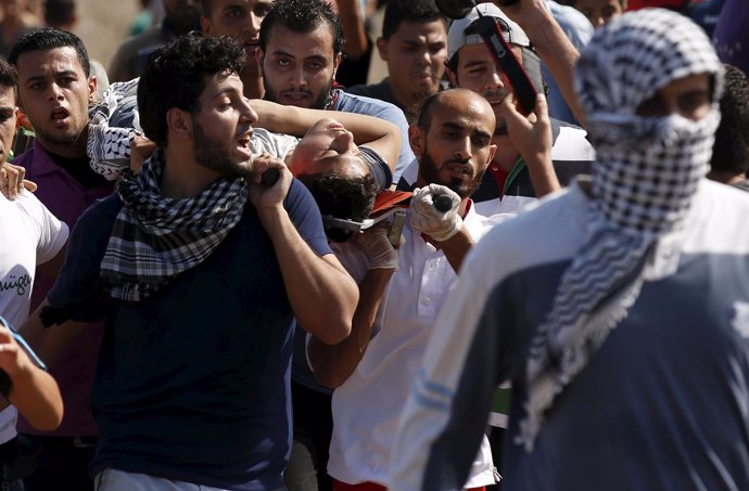 Manifestantes palestinos llevan a un herido en Gaza