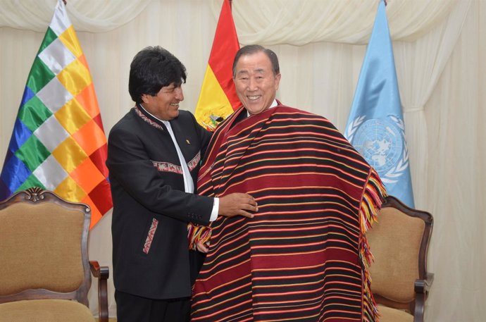 Handout photo of Bolivia's President Morales arranging a Tarabuco's "poncho" to 