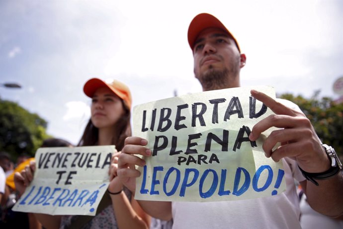 Supporters of jailed Venezuelan opposition leader Leopoldo Lopez hold placards d