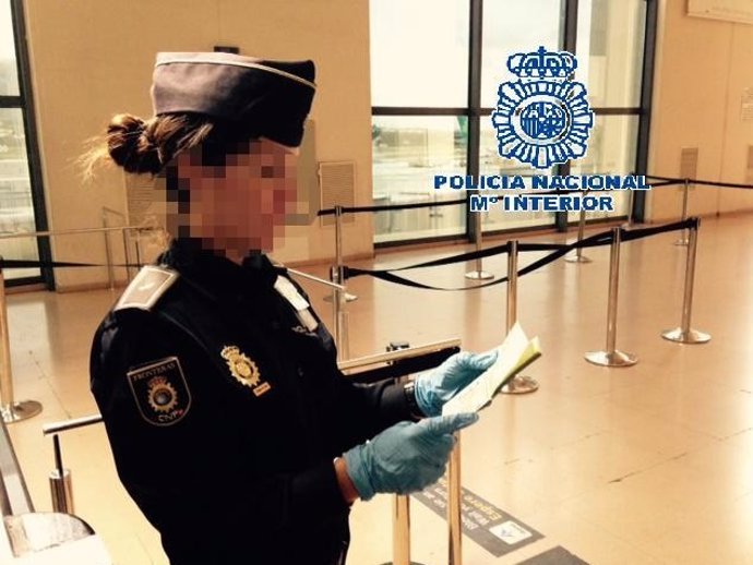 Agente policía nacional aeropuerto comprueba pasaporte identidad seguridad