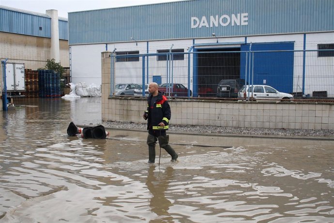 Bombero levanta una arqueta tras las inundaciones en Motril