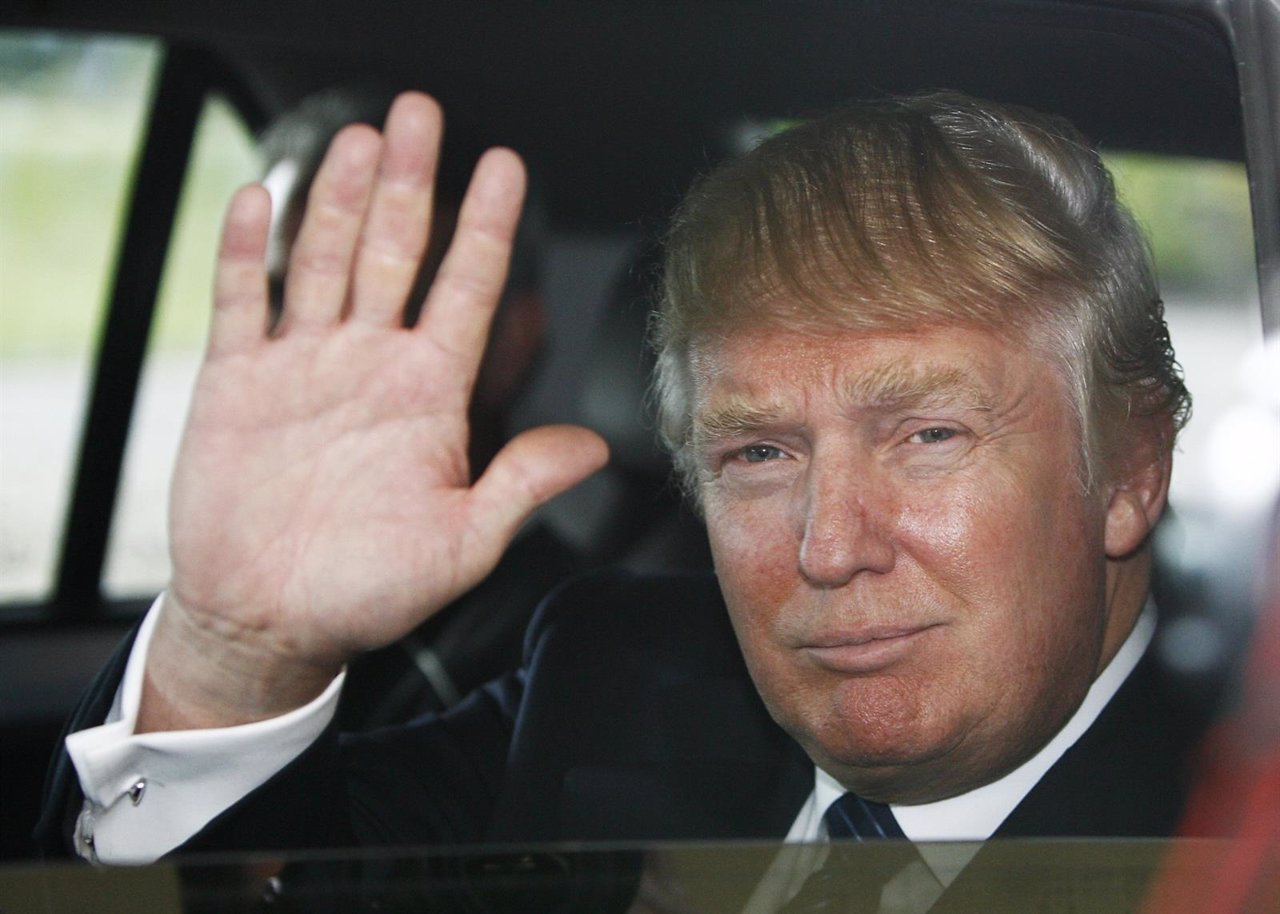 Donald Trump waves as he leaves an Aberdeenshire Council inquiry into the plans 