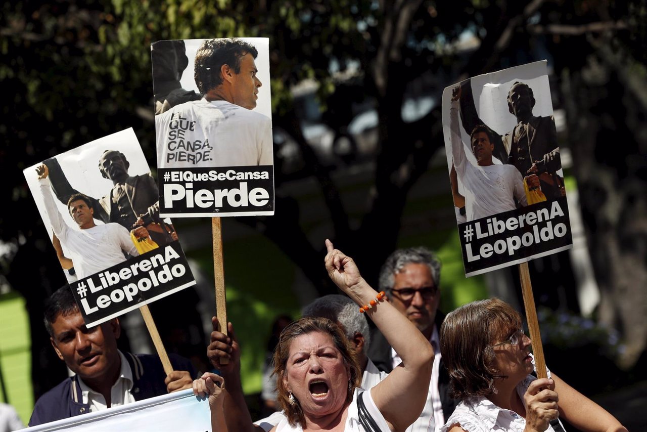 Supporters of jailed opposition leader Leopoldo Lopez shout as they hold placard