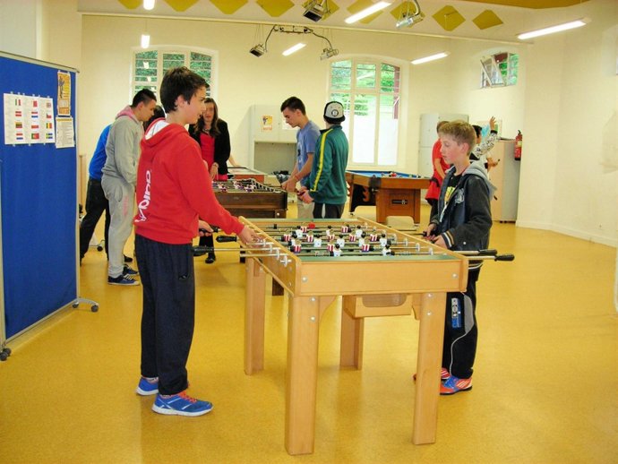 Programa de ocio juvenil. Jóvenes jugando al futbolín. 