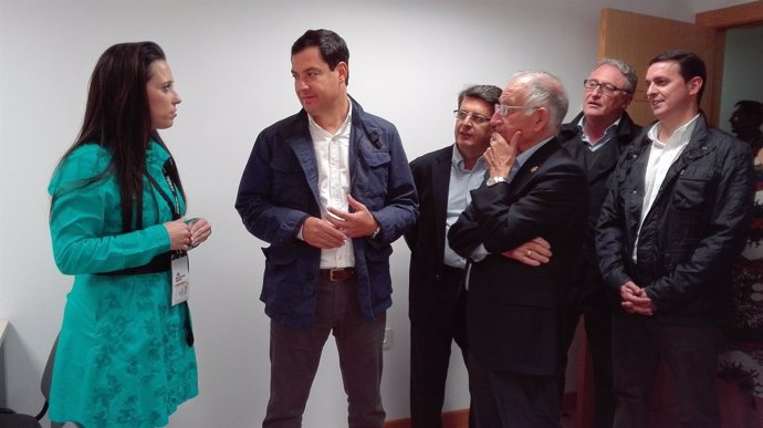 El presidente del PP-A, Juanma Moreno, charla con una empresaria
