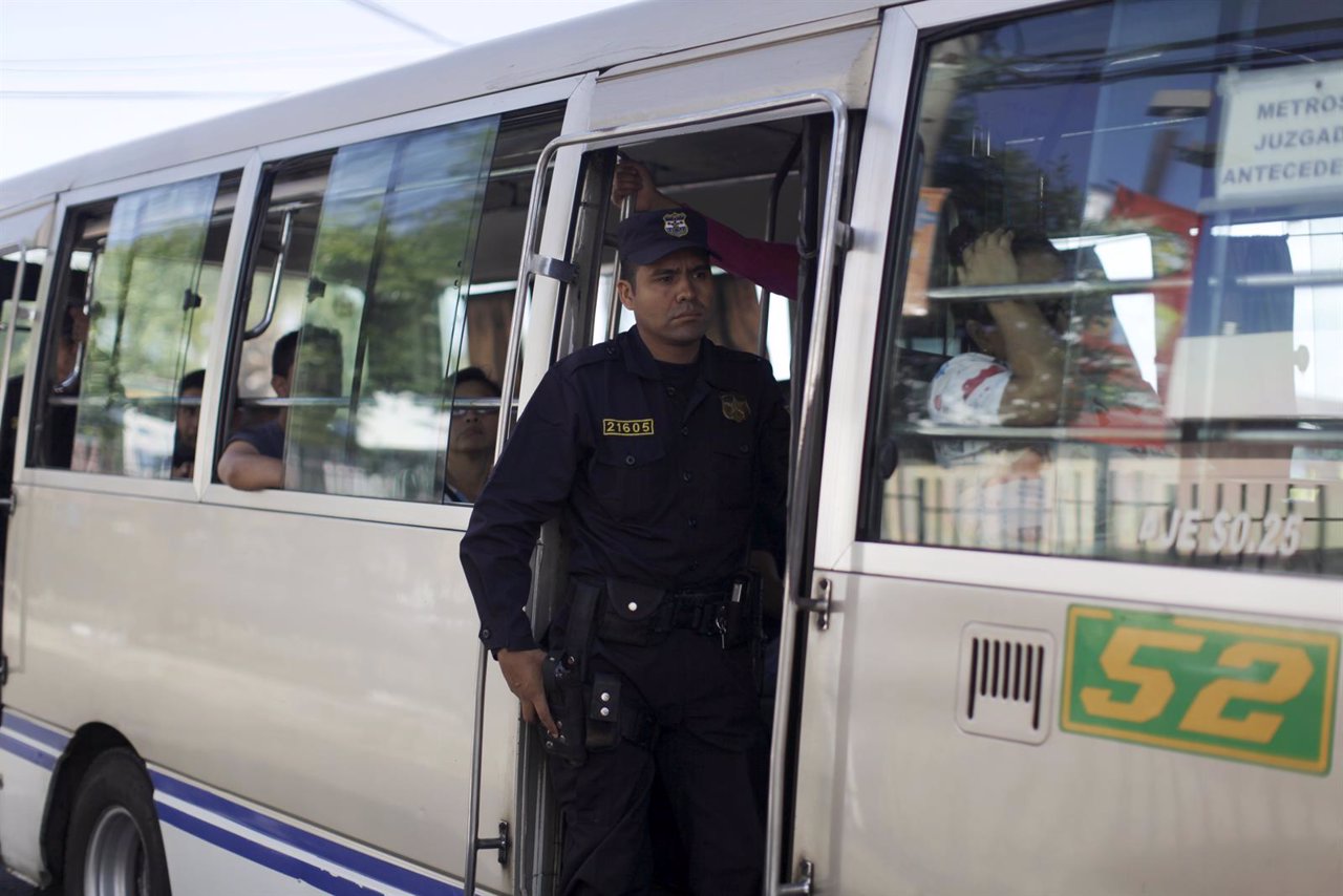Un policía custodia un autobús en la capital de El Salvador