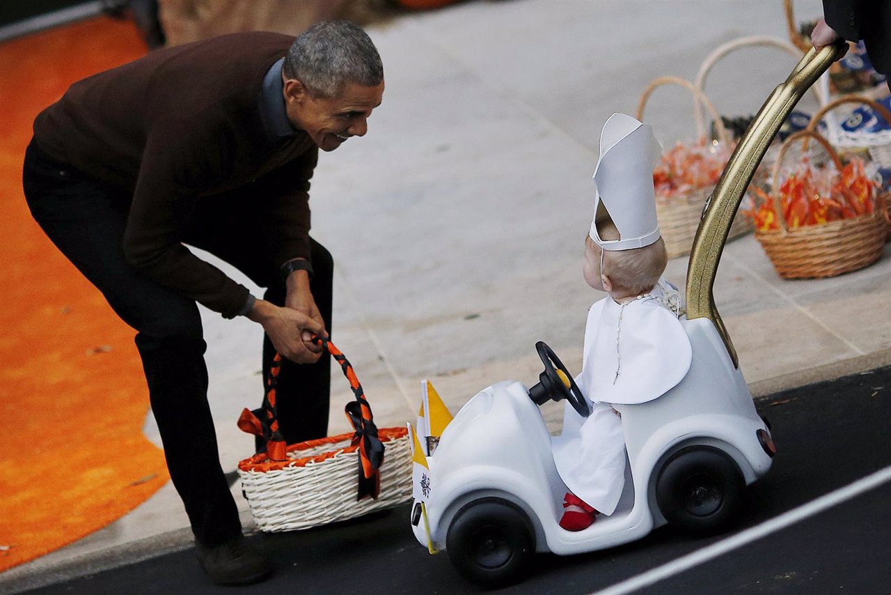 U.S. President Barack Obama receives a child dressed as Pope Francis on the Sout