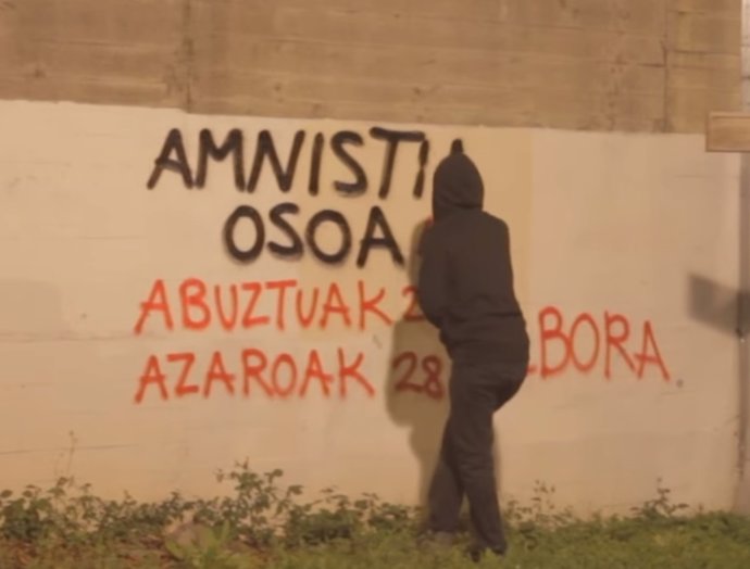 Encapuchado hace pintadas llamando a la manifestación