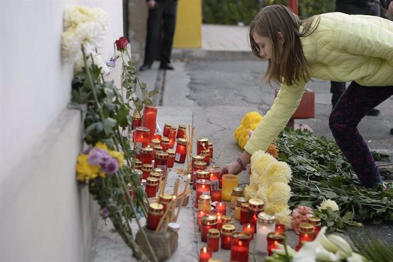 Una joven deposita flores tras el incendio de una discoteca en Bucarest