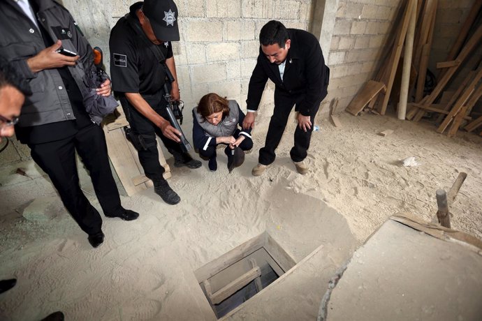 Mexico's Attorney General Gomez Gonzalez looks into the entrance of a tunnel con