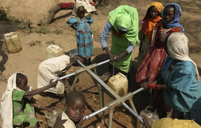 Sudanese refugees from southern Darfur collect water from well at a camp in Sam 