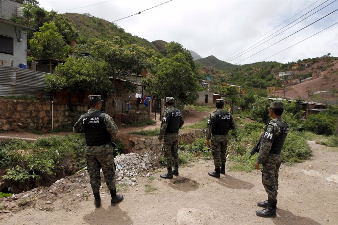 Members of the Military Police for Public Order (PMOP) patrol an impoverished ne