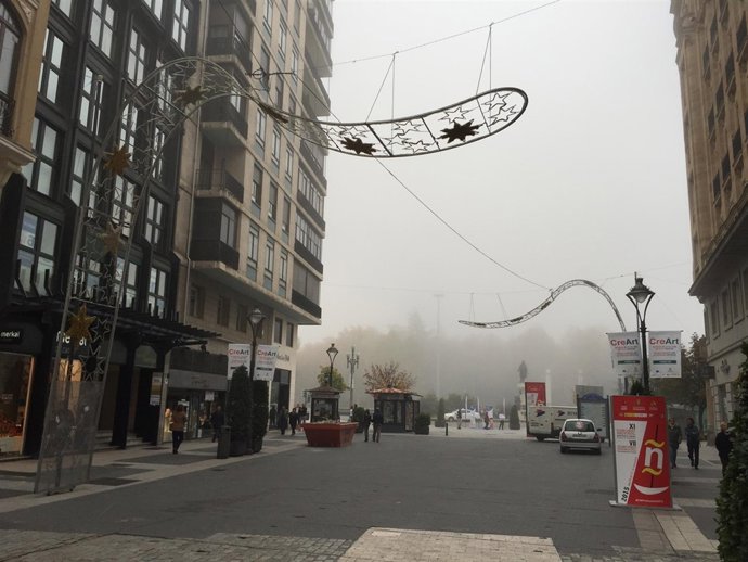 Arcos de luces de Navidad ya instalados en la calle Santiago con niebla