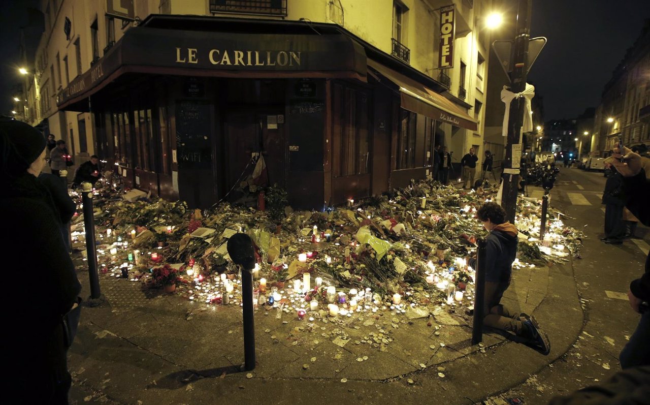 Gente rezando en el restaurante Le Carillon, atacado por los yihadistas en París