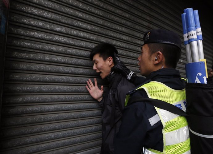 Un policía chino detiene a una persona