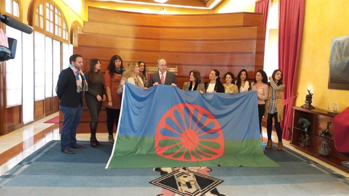 Miembros de Fakali entregan la bandera gitana al presidente del Parlamento