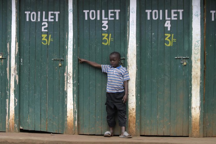 Niño señalando un baño, retrete