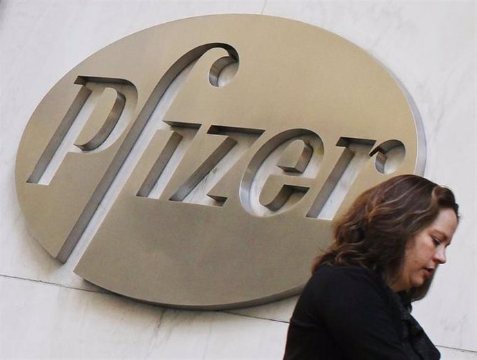 Una mujer camina frente a la sede de la farmacéutica Pfizer en Nueva York
