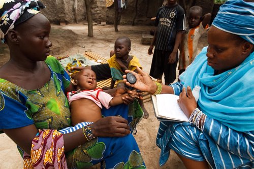 Una voluntaria atiende a un niño aquejado de neumonía en África
