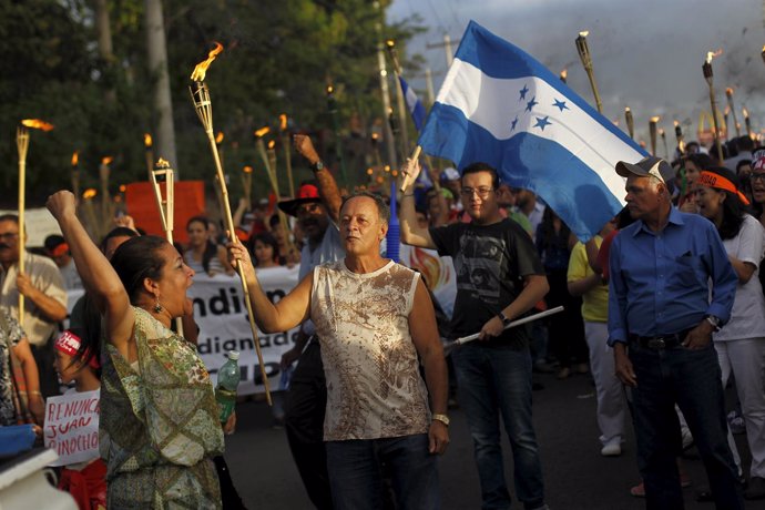 People take part in a march to demand the resignation of Honduras' President Jua