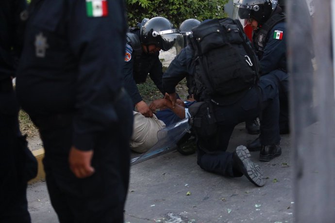 Policias federales deteniendo a un normalista.